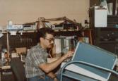 Color photograph of an individual sitting and working at a computer.