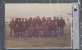 Color photograph of twenty-three individuals posing outside for a photo. A written caption on the plastic photo holder reads "Aero Club 1990-1991".